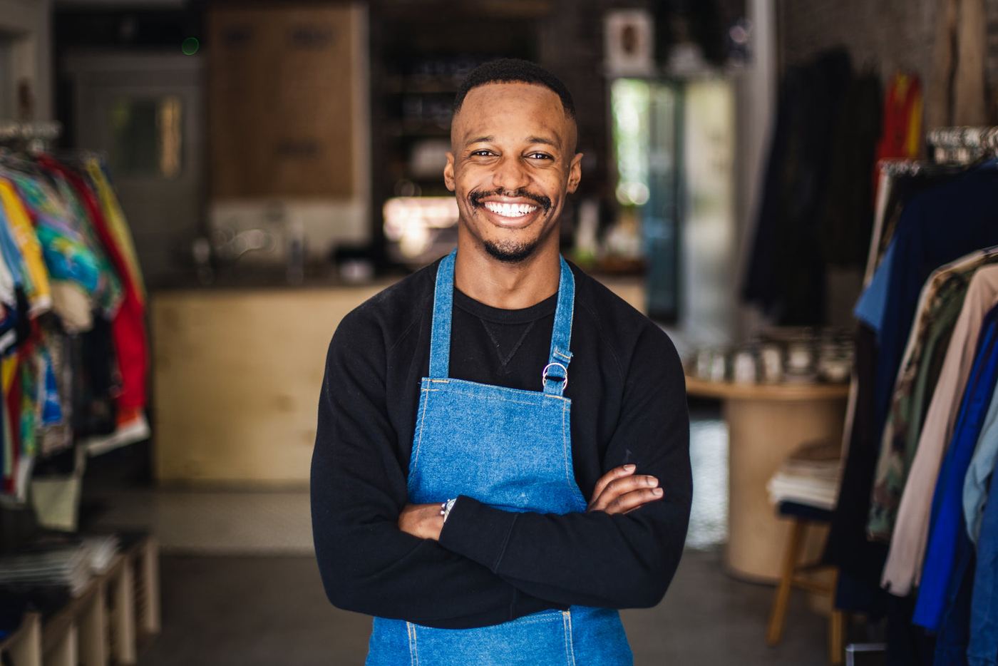 A smiling store owner in an apron