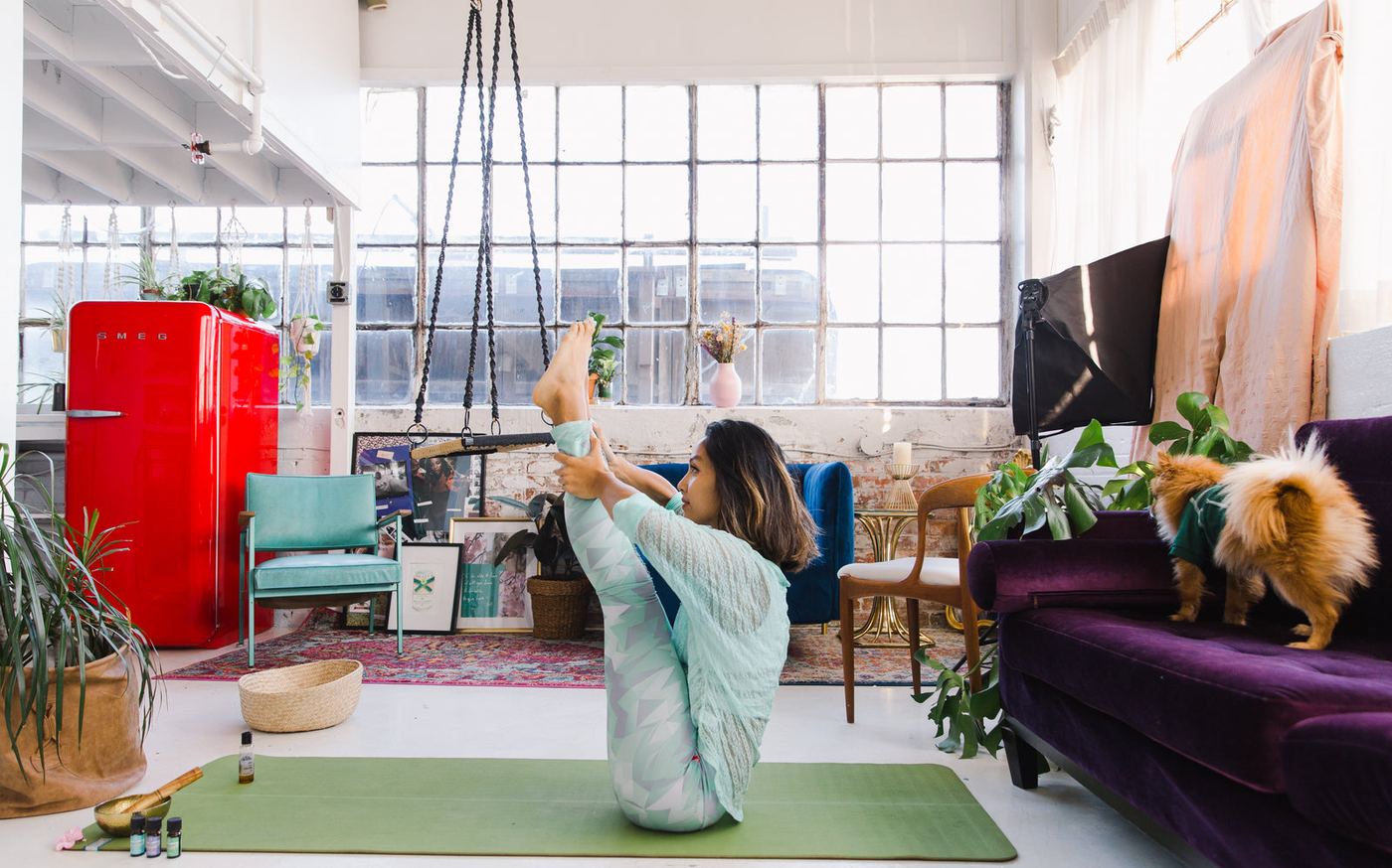 A yoga instructor holding a balance pose in a bright studio