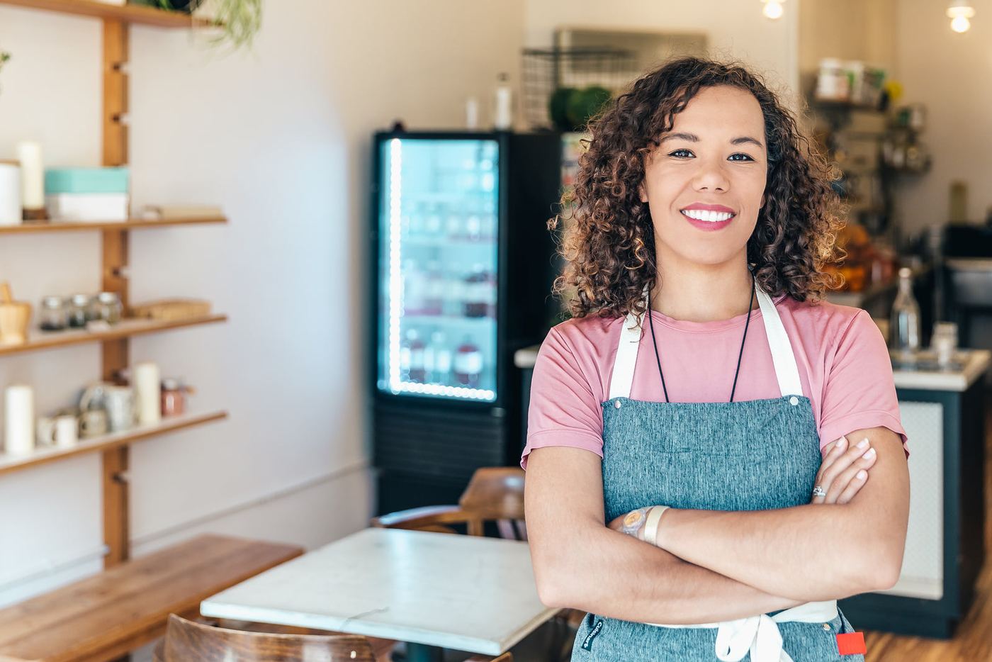 A smiling café owner standing in her café